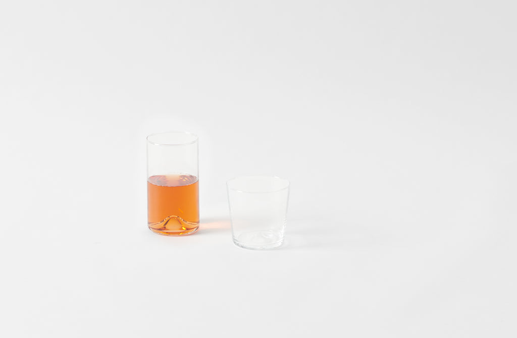 Clear glass with orange liquid on a white background. Default