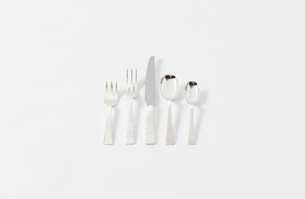 Set of silver cutlery including forks, knives, and spoons on a white background