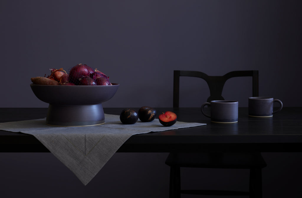Christiane Perrochon plum centerpiece atop Peter Speliopoulos granite linen hemstitch napkin