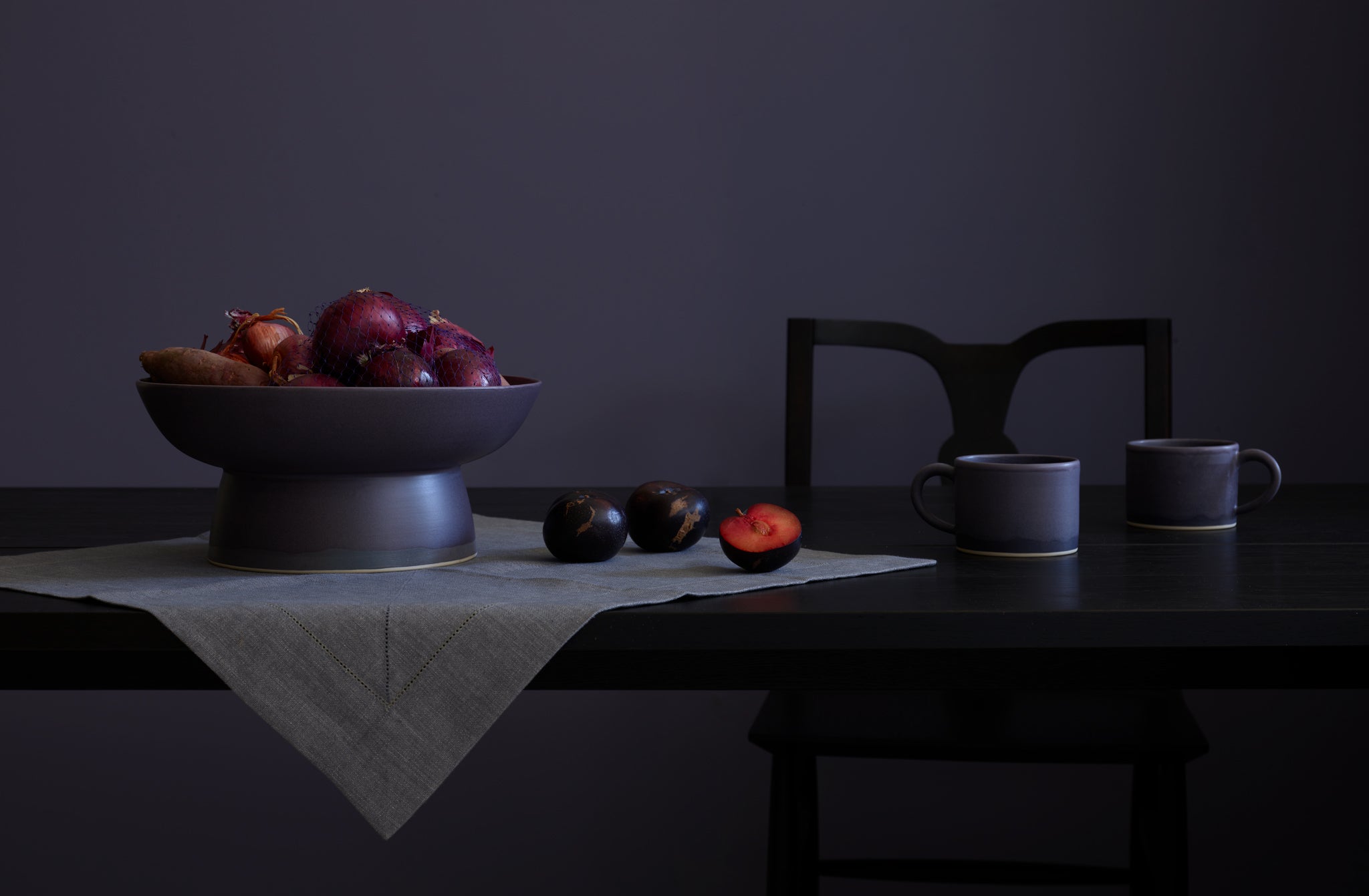 Christiane Perrochon plum centerpiece atop Peter Speliopoulos granite linen hemstitch napkin