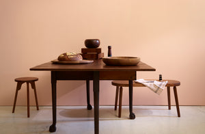 Antique Walnut table set with walnut objects next to Long Confidence walnut bench and Ifuji walnut stool
