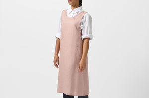 Model wearing MARCH At Work dusty pink linen cross back apron.