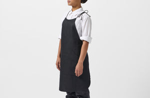 Model wearing MARCH Boxwood linen black work halter apron.