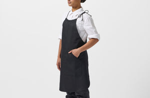 Model wearing MARCH Boxwood linen black work halter apron.