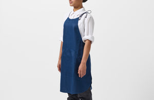 Model wearing MARCH Boxwood linen indigo work halter apron.