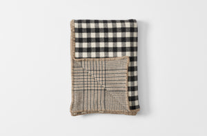 Checked cashmere blanket folded with houndstooth reverse visible 