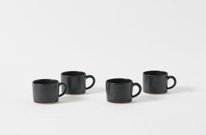 Four Christiane Perrochon black mugs.