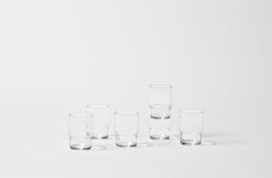 Six glass stacking tumblers on white background