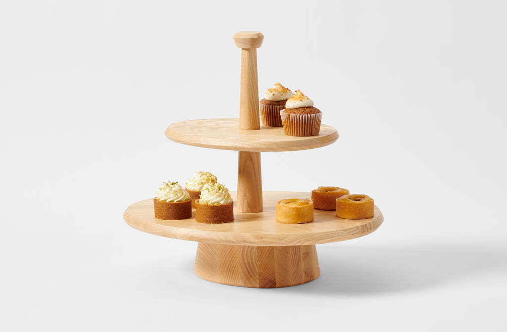 Kelly Wearstler two tier white ash cake stand holding petite cakes