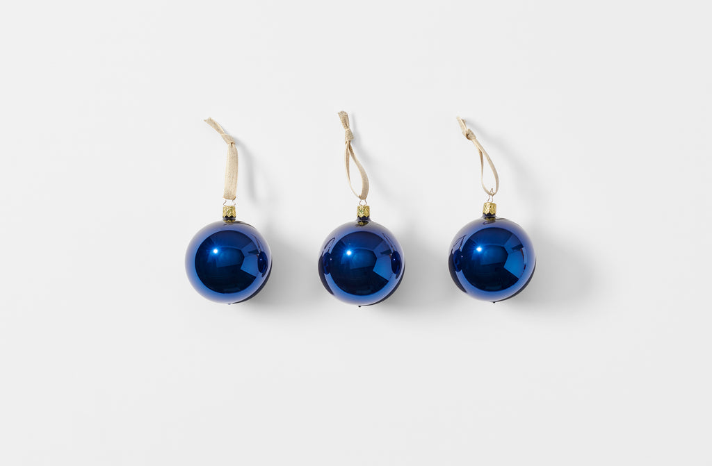 Three midnight glass ball ornaments strung with linen tape