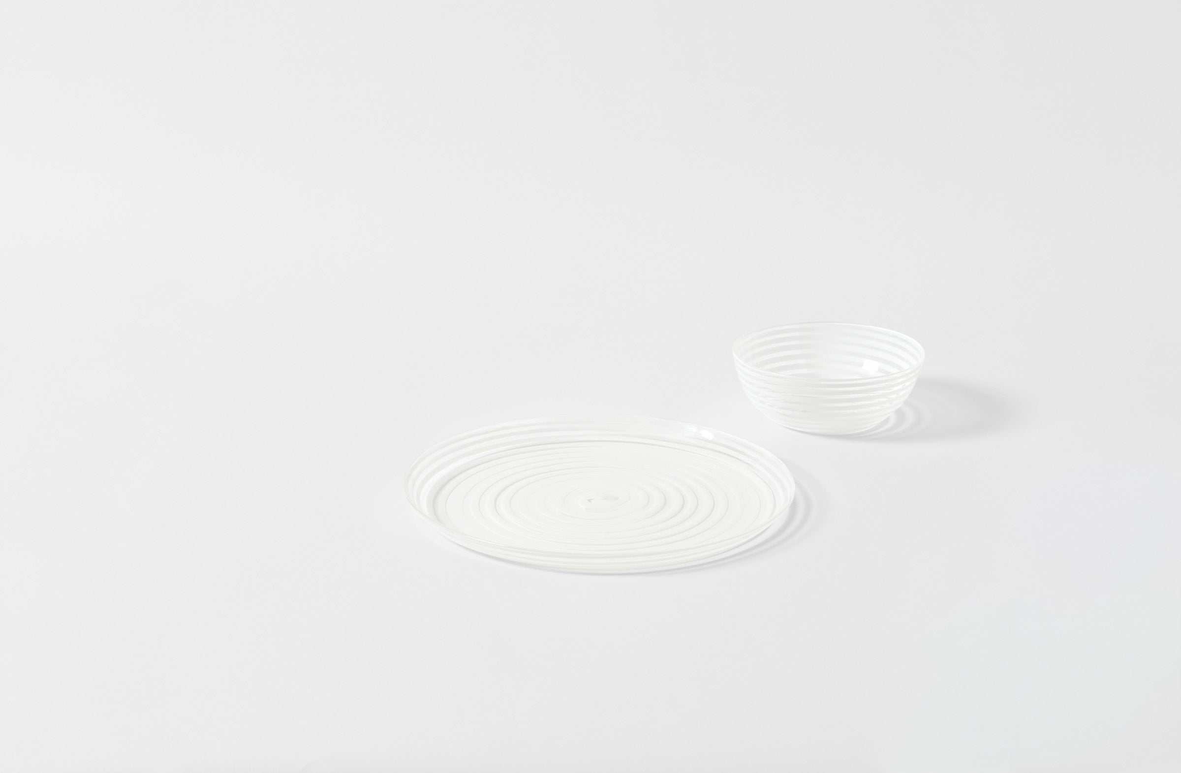 Murano striped white glass dinnerware on a light gray background. Default