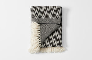 Vigo black and ecru woven blanket with fringe folded with detail of reverse