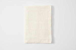 Ivory linen windowpane tablecloth folded.