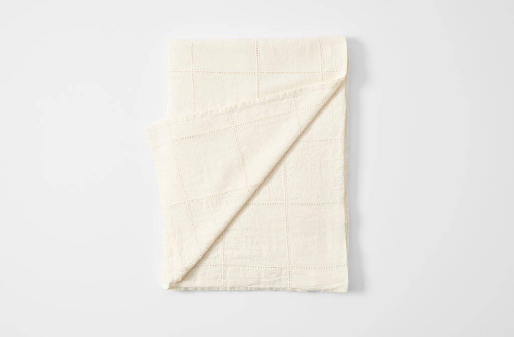 Ivory linen windowpane tablecloth folded with detail of reverse
