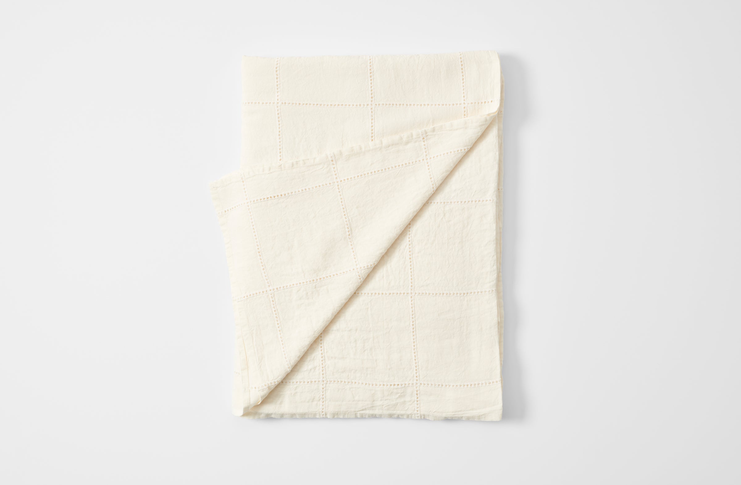 Ivory linen windowpane tablecloth folded with detail of reverse