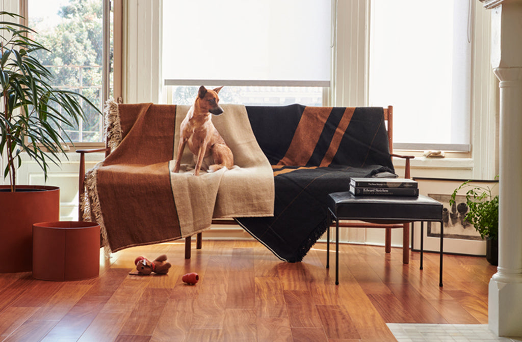 Libeco-linen-throw-blankets-draped-over-brian-persico-wood-sofa-with-Michael-Verheyden-leather-baskets-MARCH