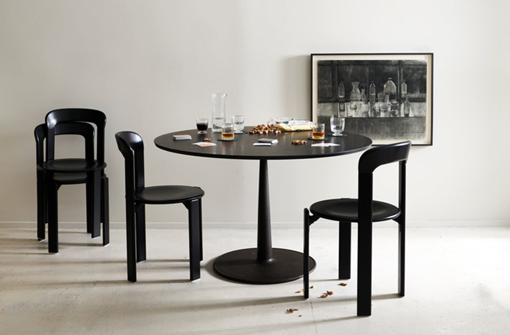 MARCH-joshua-vogel-marble-and-cast-iron-table-with-bruno-rey-black-chairs-set-for-a-card-game-with-jason-line-framed-drawing-of-glassware-hanging-behind