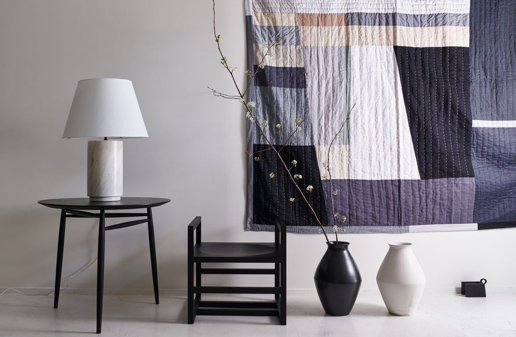 Michael-Verheyden-cube-Chair-and-large-marble-Lamp-on-sawkille-black-spindle-table-with-thompson-street-Quilt-Background-and-christiane-perrochon-vases-on-floor