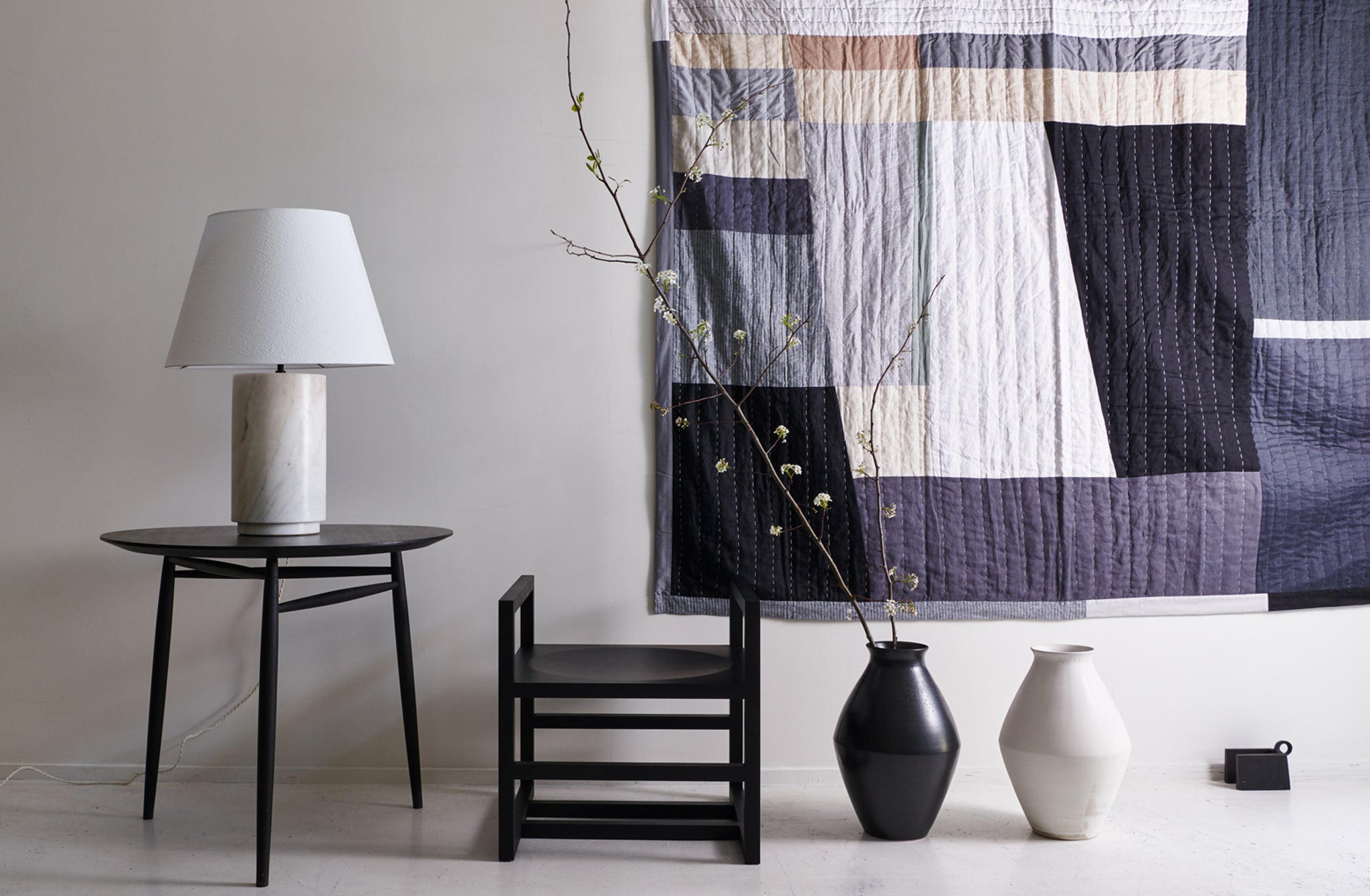 Michael-Verheyden-cube-Chair-and-large-marble-Lamp-on-sawkille-black-spindle-table-with-thompson-street-Quilt-Background-and-christiane-perrochon-vases-on-floor