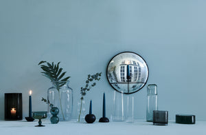 Mixed-glassware-including-teal-vase-and-goblet-on-teal-background-with-maureen-fulham-sconce-mirror-and-commune-bronze-totem-candlesticks-with-teal-tapers-Default