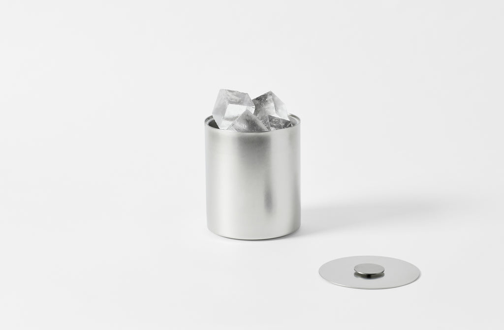 stile pewter steel ice bucket with a matte finish with the lid off and to one side and set with large ice cubes