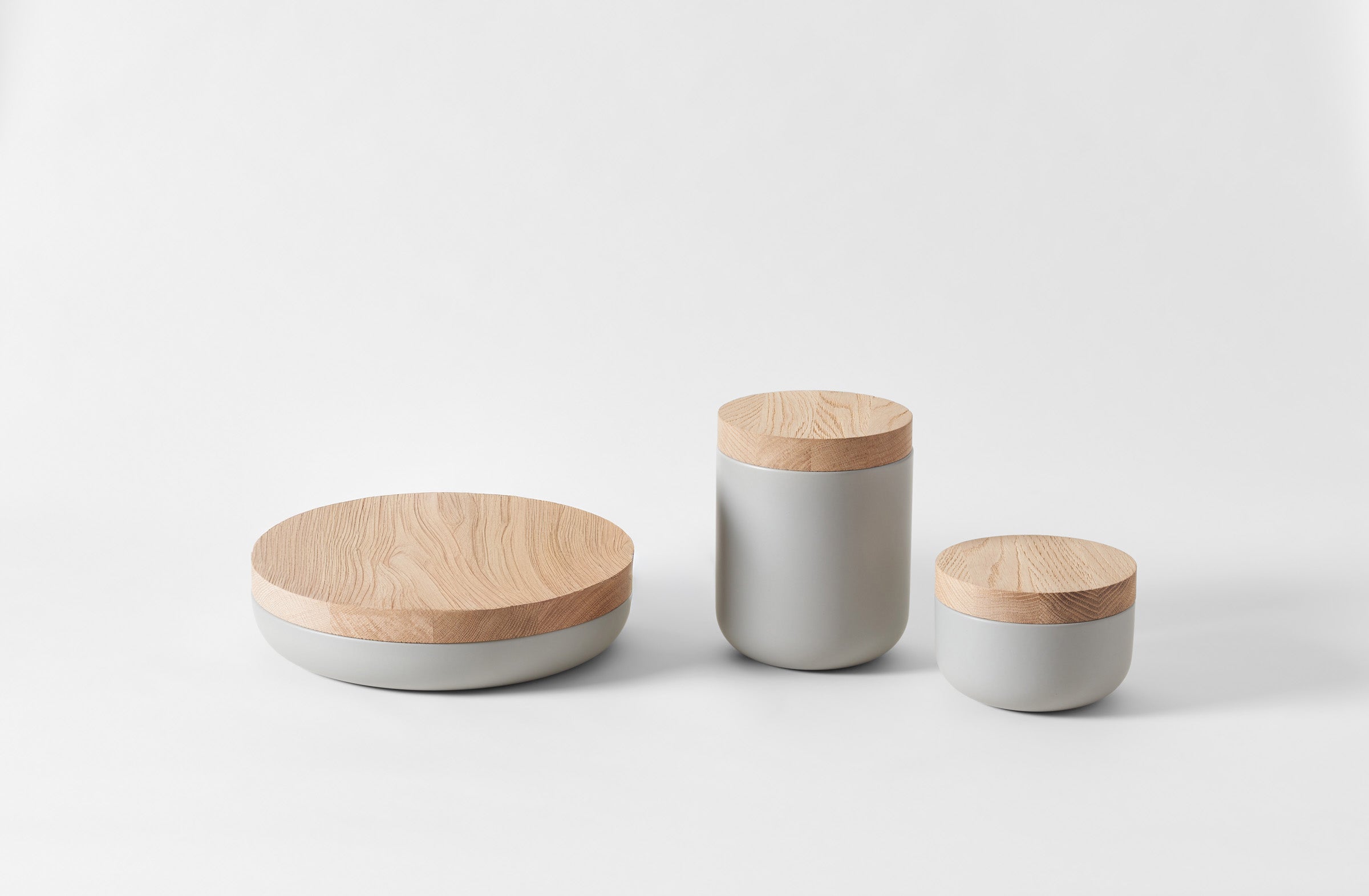 Three cylindrical containers with wooden lids on a white background. Default 