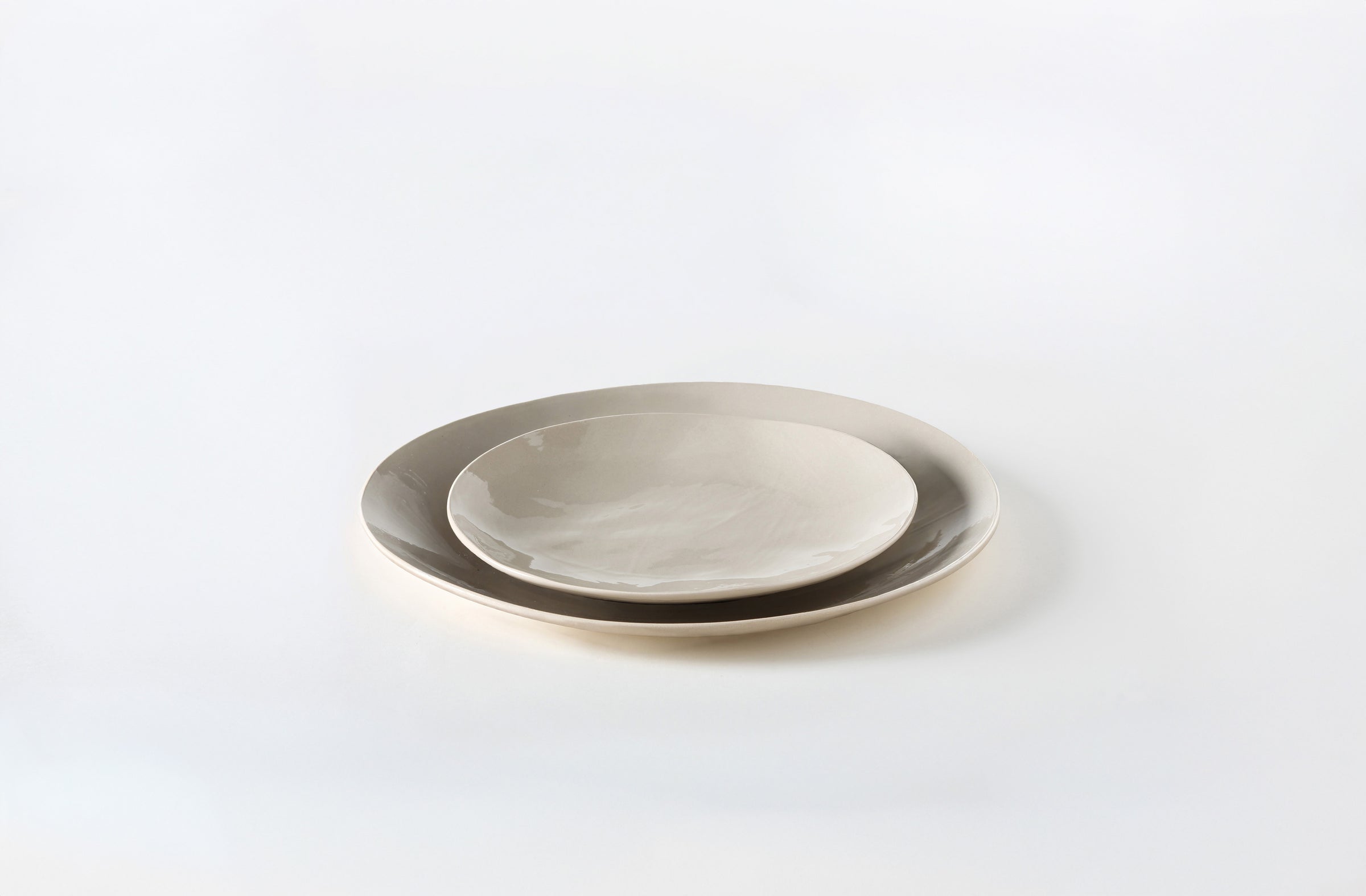 Two Brickett Davda taupe plates stacked on a white background. Default