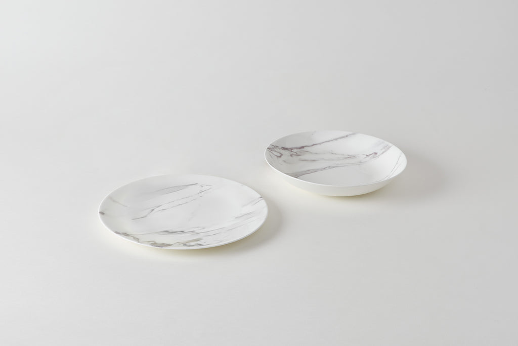 Two marble-patterned bone china plates on a light gray background. Default