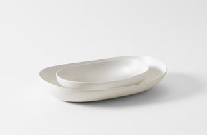 Nested white ceramic bowls on a white background. Default