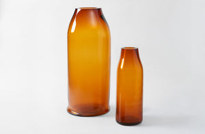 Two amber glass bottles on a white background. Default