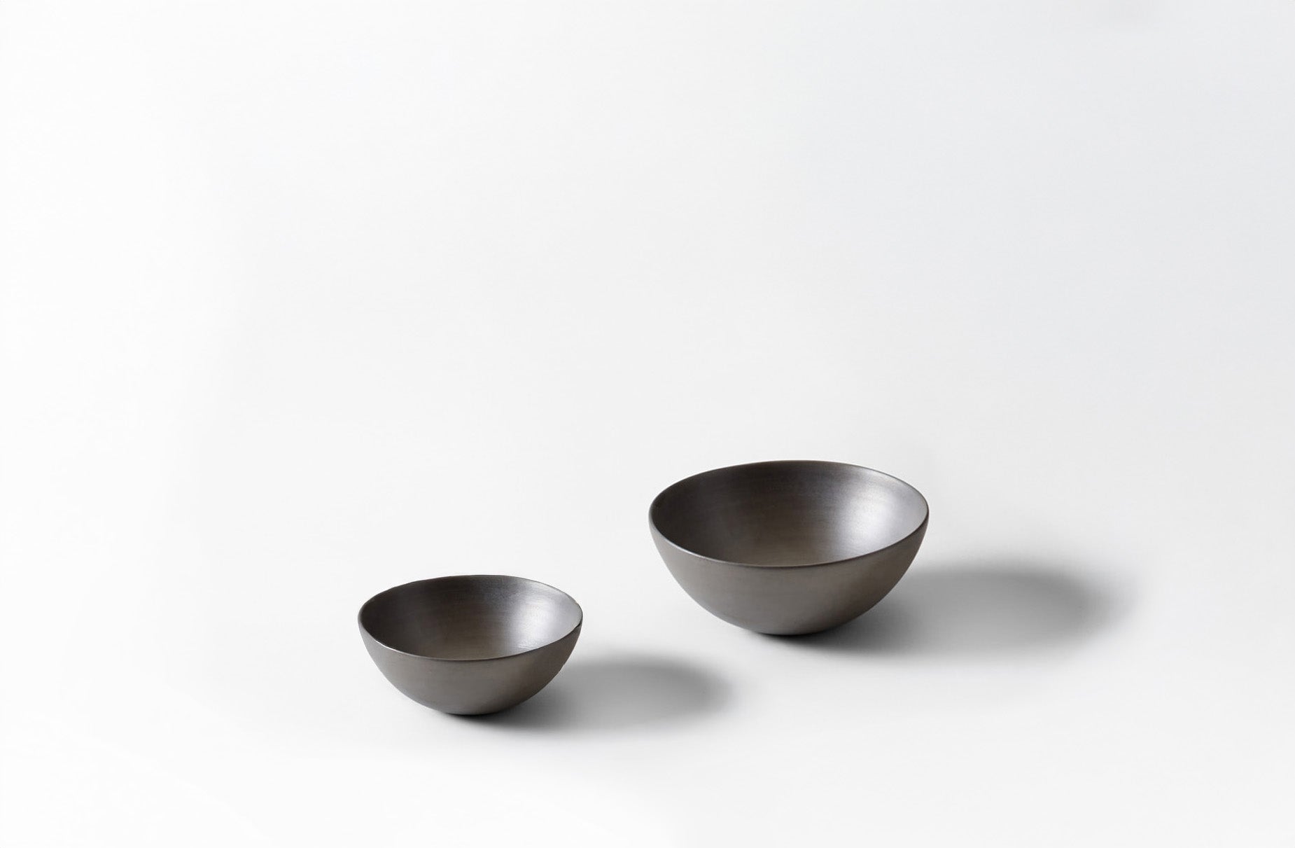 Two metallic bowls on a white background. Default