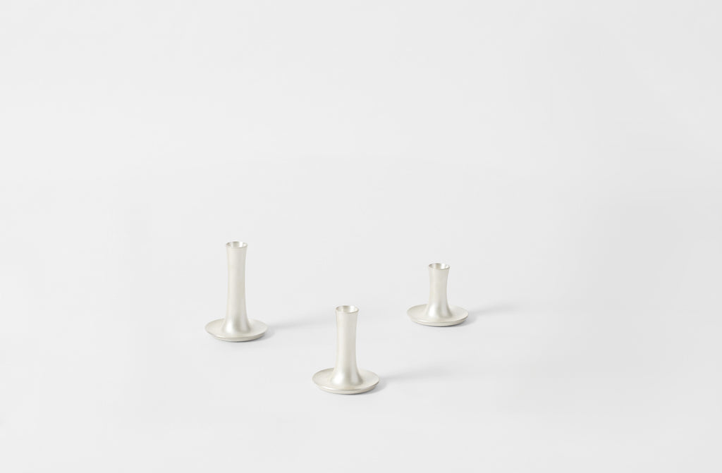 Three Ted Muehling silver pumiced candle holders on a white background. Default