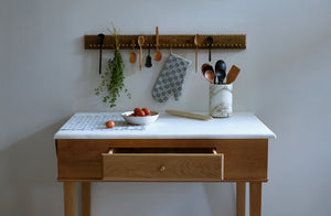 White oak bakers table with marble top ready for a project with Christiane Perrochon bowl filled with eggs Tori Murphy kitchen towel and oven mitt and various wooden spoons in Michael Verheyden marble fresco bottle holder.