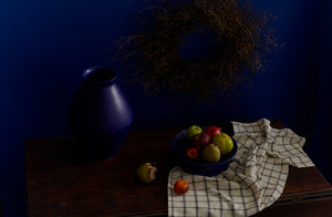 Christiane Perrochon blue violet vase and bowl holding apples with cooks cloth kitchen towel