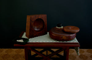 Walnut Christopher Norman sculptures with Christiane Perrochon bottle green mug and Woven by Laura black coaster set on top of Chiarastella Cattana dark green check runner.