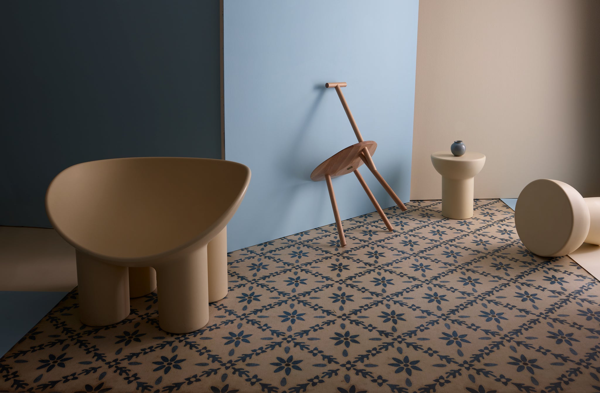 Artful arrangement of cream Faye Toogood furniture pieces on pattened floor with Christiane Perrochon iron blue petite boule on side table.