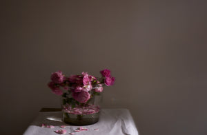 Henry-dean-extra-large-clear-glass-vase-filled-with-decaying-pink-garden-roses-dropping-their-petals