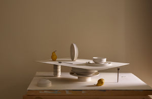 Sculptural arrangement of Kelly Wearstler Dune Dinnerware with Stile flatware and pears. Default.