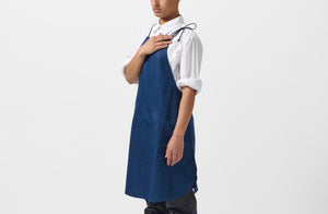 Model wearing MARCH Boxwood linen indigo work halter apron.