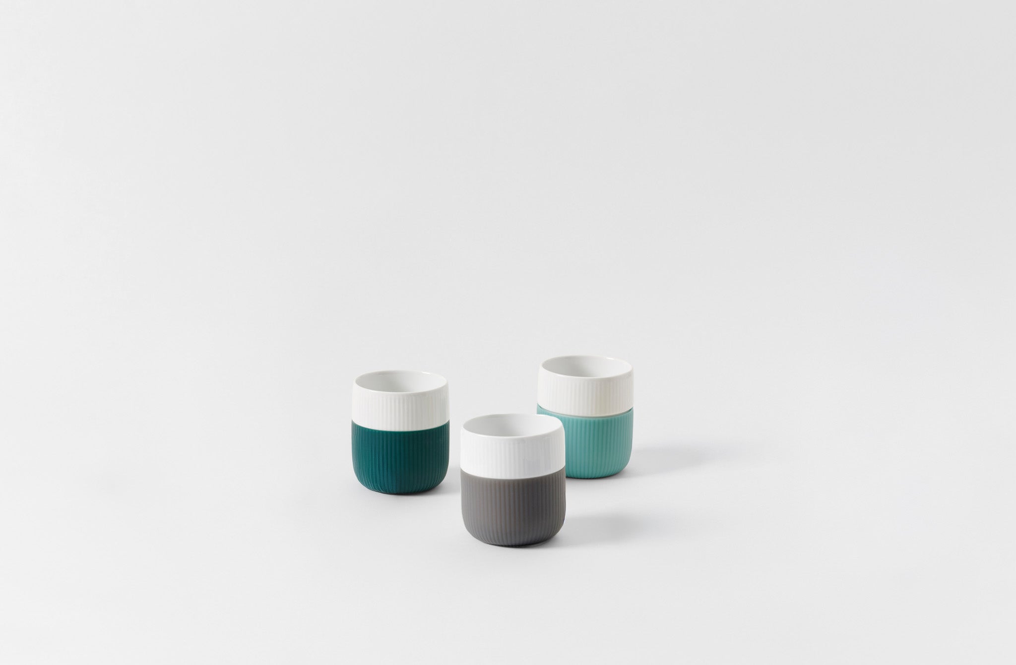 Three Royal Copenhagen porcelain and silicone contrast mugs on a white background. Default 