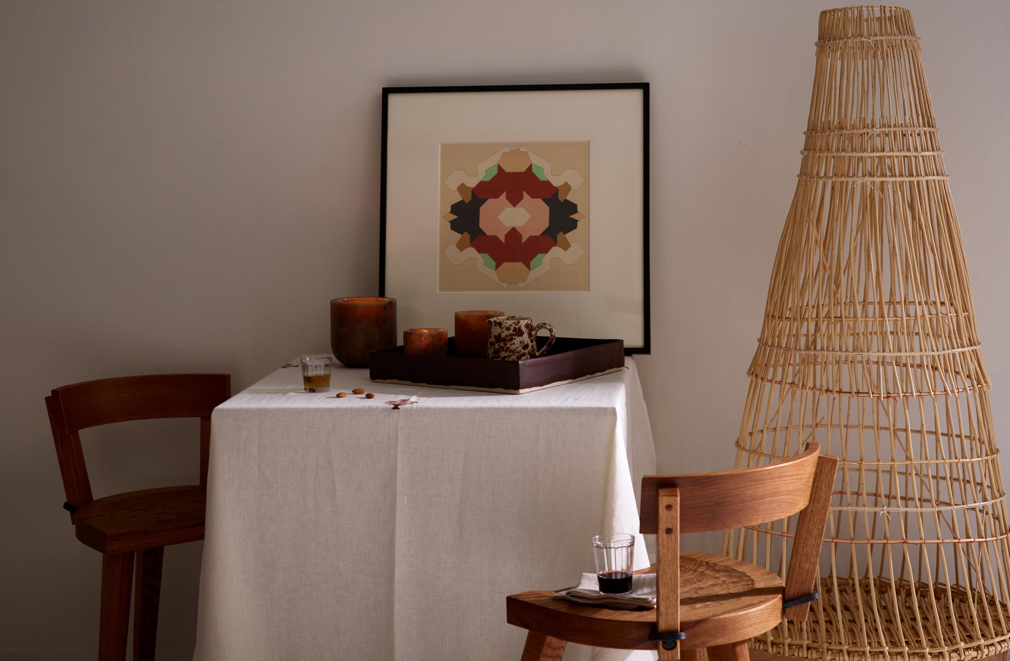 marolles chairs set at small square table set with Michael Verheyden alabaster votives with woven sculpture to one side