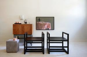 Michael verheyden cube chairs and side table set in front of antique butcher block and susan ashworth painting