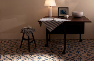 Michael Verheyden petite panser lamp and concrete bowl on antique 19th century mallorca table with blue and cream ticking stripe kitchen towels and Carol Leskanic short gesso candlestick.