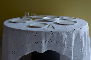 Molosco white dinnerware and serving bowl with gold rim set for entertaining on a Italian sangallo tablecloth against a gold green wall. Default 