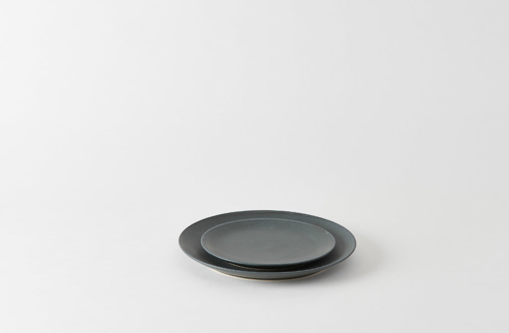 Black ceramic plate on a white background. Default 