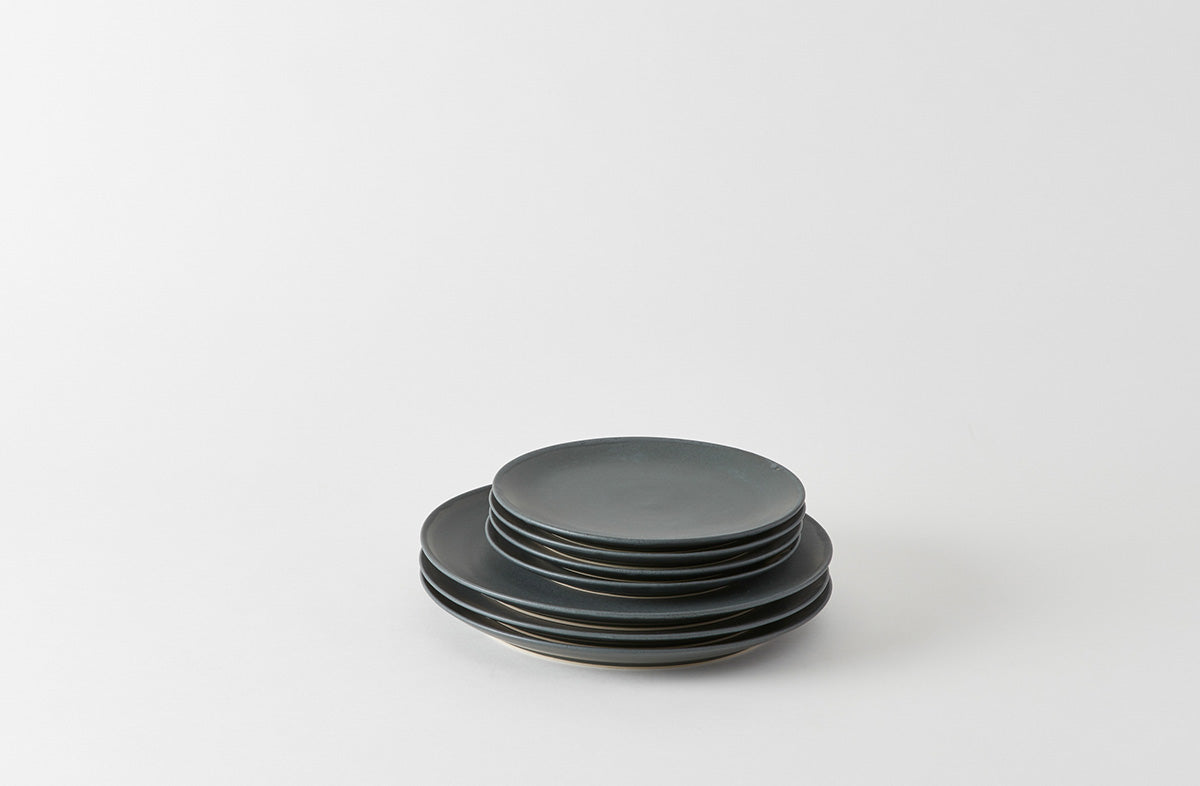 Stack of black ceramic plates on a white background. Default
