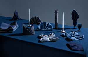 Peter Speliopolous formal folded napkins in denim blues and tablecloth set with silver ted meuhling candlesticks and davide fuin murano goblets
