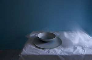 Rina Minardi shaded water extra large round peel and extra large round bowl on table with white tissue paper showing movement.