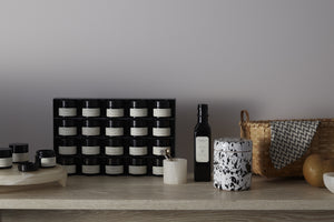 Collection of candles and bottles on a wooden surface with a neutral background. Default 