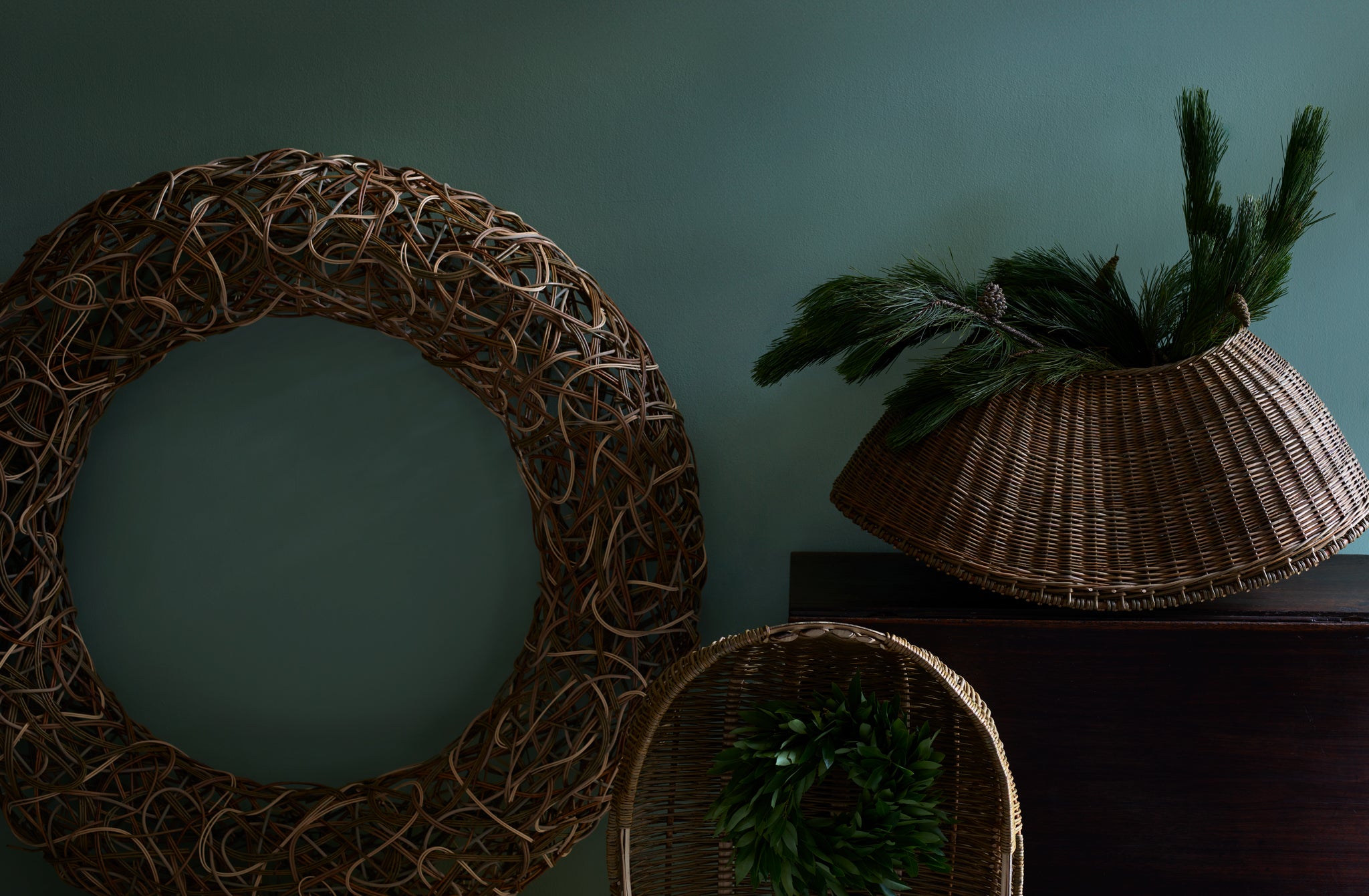 Studio Amos random woven wreath line scull and fish kettle baskets with holiday greenery.